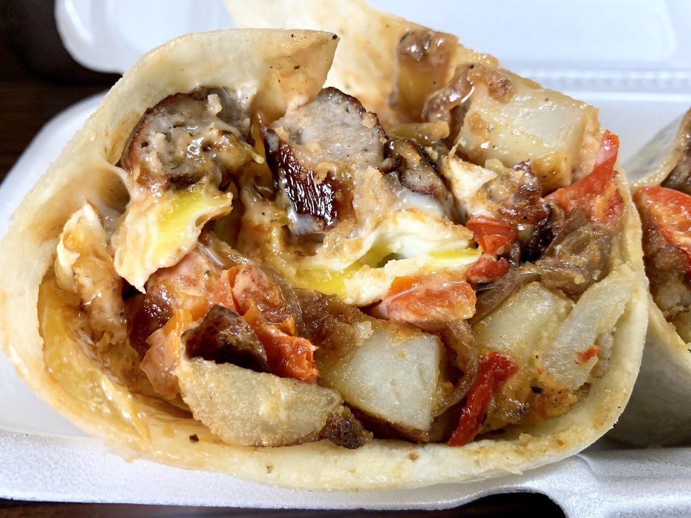 A loaded breakfast burrito on a plate