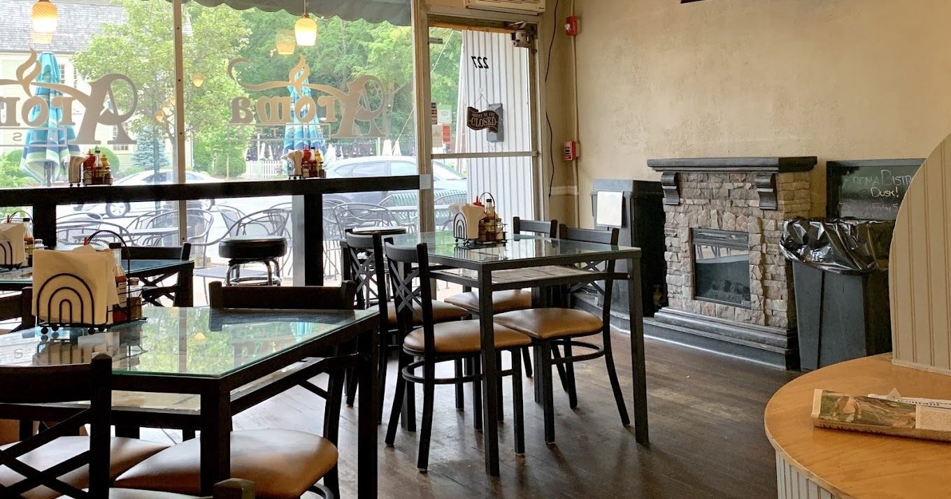 Inside Aroma Bistro — tables, a stone fireplace, and the front windows onto Main Street