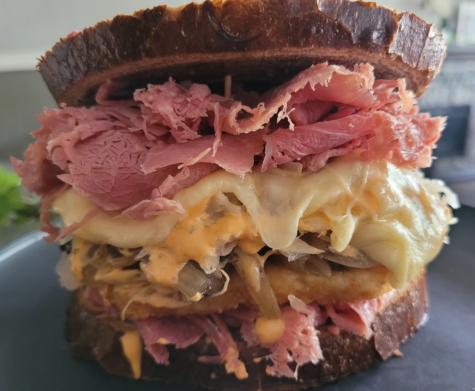 Pastrami sandwich with melted cheese on dark rye